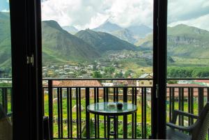 a view from a balcony with a table and mountains at Aronia Kazbegi in Stepantsminda