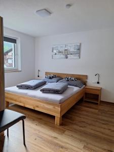 Un dormitorio con una gran cama de madera con almohadas. en Apart Madeleine, en Sankt Leonhard im Pitztal