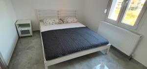 a small bed in a small room with a window at Heracles Guest house in Nea Peramos