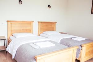 two beds with white sheets and towels on them at Aronia Kazbegi in Stepantsminda
