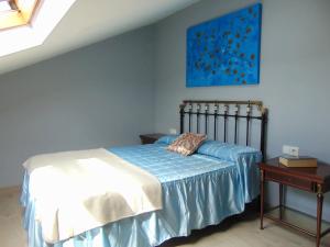 a bedroom with a bed and a painting on the wall at Casa Esperanza 8 huéspedes in Viñas
