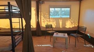 a room with two bunk beds and a table and two chairs at Les 2 etangs de la foulonnerie in Saint-Jean-Saint-Germain +21 photos