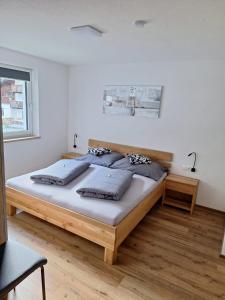 1 dormitorio con cama de madera y almohadas en Apart Madeleine, en Sankt Leonhard im Pitztal