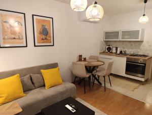a living room with a couch and a table with yellow pillows at Byt s parkovaním, balkónom, klimatizáciou, free parking in Vrakuňa