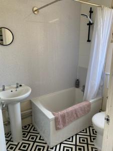 ニューマーケットにあるCharlies House Newmarket - 3 bedroomの浴槽、洗面台、トイレを備えたバスルーム