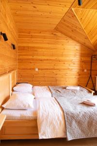 a bedroom with a bed in a wooden room at Aronia Kazbegi in Stepantsminda