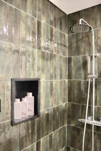 a bathroom with a shower with green tiles at Apartamento Malino in Sagres