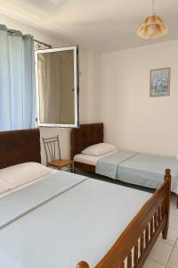 una stanza con due letti e una finestra di Hotel Ardjan a Golem