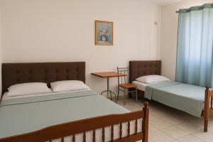 una camera da letto con due letti e un tavolo di Hotel Ardjan a Golem
