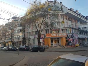 a street with cars parked in front of a building at апартамент Хармония in Gotse Delchev