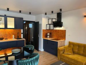 a kitchen and living room with a couch and a table at Baltic Vip Apartamenty przy morzu in Rewal