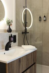 a bathroom with a sink and a shower with a mirror at DREAMSPACE Frankfurt Airport in Kelsterbach