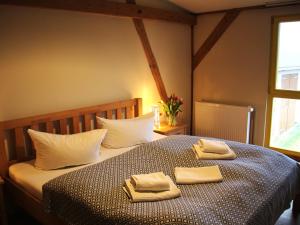 a bedroom with a bed with two towels on it at Pension Bäumi-Hof in Seehausen