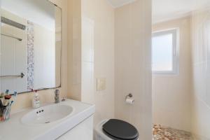 Un baño con lavabo, inodoro y espejo. en Constance d'Azur - Climatisé vue mer, en Le Lavandou 4 fotos más