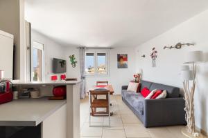 una sala de estar con un sofá y una mesa en Constance d'Azur - Climatisé vue mer, en Le Lavandou