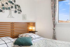 un dormitorio con una cama y una ventana en Constance d'Azur - Climatisé vue mer, en Le Lavandou
