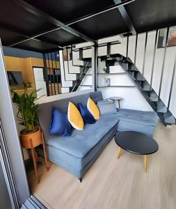 ein Wohnzimmer mit einem blauen Sofa und einer Treppe in der Unterkunft Loft Design na Vila Mariana in São Paulo