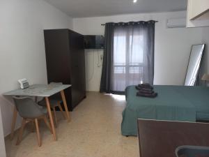 a small living room with a table and a bed at Sophie's Sunny Spot 5 in Yéfira