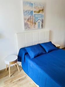 a bedroom with a blue bed and a table at Marina Beach-Apartamentos Tahiche in Costa Teguise