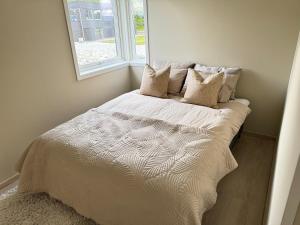 a bed in a room with a window at Exclusive penthouse apartment near the sea and nature - Sæbøvik in Sæbøvik