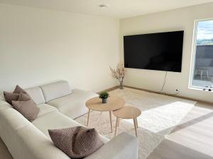 a white living room with a couch and a table at Exclusive penthouse apartment near the sea and nature - Sæbøvik in Sæbøvik