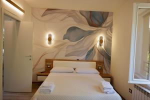 a bedroom with a bed with a painting on the wall at Lecco Rivers Retreat - Five Design Suites in Lecco