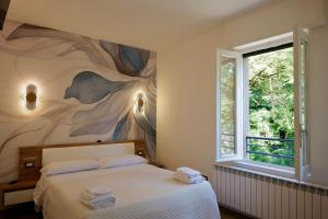 a bedroom with a bed with a painting on the wall at Lecco Rivers Retreat - Five Design Suites in Lecco