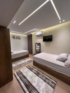 a bedroom with two beds and a flat screen tv at apartment cornish el nile floor 14 in Cairo