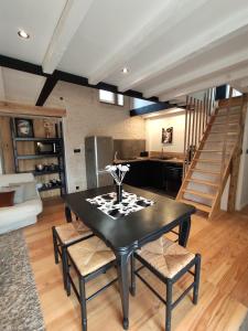 a dining room with a black table and chairs at Maison cosy au cœur du Marais Poitevin in Benet