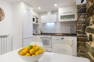 a kitchen with a bowl of fruit on a counter at Apartamento con jardín en San Sadurniño in Santa María La Mayor del Rosario