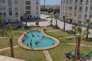 a group of people playing in a swimming pool at Fabuleux Appartement bien équipé à Agadir in Agadir