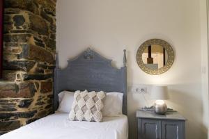 a bedroom with a bed and a mirror on the wall at Apartamento con jardín en San Sadurniño in Santa María La Mayor del Rosario +15 photos