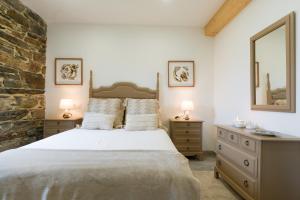 a bedroom with a large bed and a stone wall at Apartamento con jardín en San Sadurniño in Santa María La Mayor del Rosario