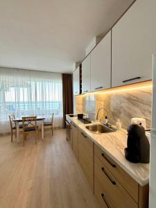 Una cocina con un fregadero y una mesa dentro. en Byala sea view apartment Studio, en Byala