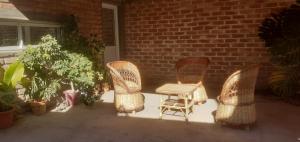 three wicker chairs and a table on a patio at María del Valle Alojamientos in Belén +2 photos
