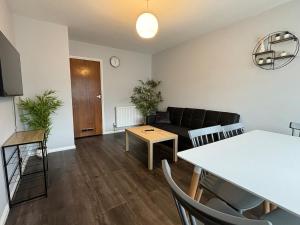 a living room with a couch and a table at 4 Bed House - Free Parking - 8 min LGW Airport in Crawley
