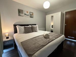 a bedroom with a large bed with a hat on it at 4 Bed House - Free Parking - 8 min LGW Airport in Crawley