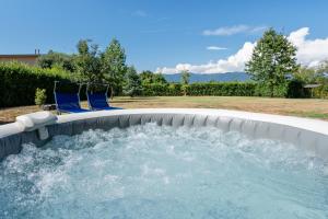 a plunge pool in a backyard with two blue chairs at Villa Angela in Capannori