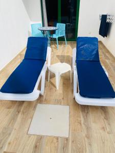 two beds and a table and chairs in a room at Marina Beach-Apartamentos Tahiche in Costa Teguise