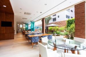 a dining room with tables and chairs in a building at Flat Estanconfor Santos na Quadra da Praia com Vista do Mar in Santos