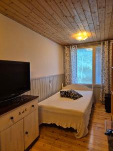 a bedroom with a bed and a flat screen tv at Kutala Cottage in Kutala +26 photos