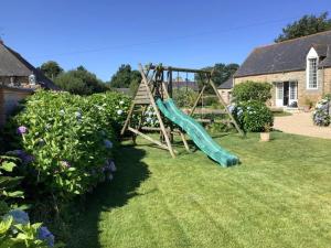 a playground in a yard with a green slide at La Belle Hermine in Tonquédec
