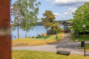 a park with a bench next to a lake at Vår Gård Saltsjöbaden in Saltsjöbaden