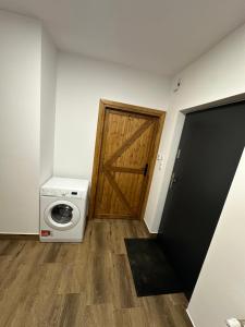a washer and dryer in a room with a door at Apartament przy sadzie in Szczytno
