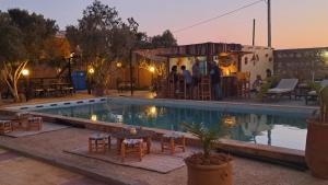 una piscina con tavolo e sedie accanto a un edificio di L'abri côtier by Nath a Sidi Kaouki