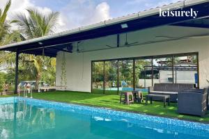 une maison avec une piscine à côté d'un bâtiment dans l'établissement StayLeisurely The Leisure Lab 5BHK, Khopoli, à Jambhulpāda