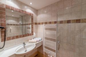 a bathroom with a tub and a sink and a mirror at Peterbauerhof in Ramsau am Dachstein