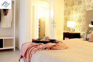 a bed with a tray with a cup on it at Il Melograno Glam by TuscanyWeGo in Prato