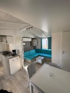 un soggiorno con un divano blu in una roulotte di Mobil home familial avec terrasse et bord de mer ad Argelès-sur-Mer