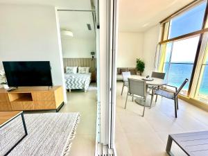 a living room with a television and a table with chairs at Intempo by Holuxe - 176 - 17th floor in Benidorm